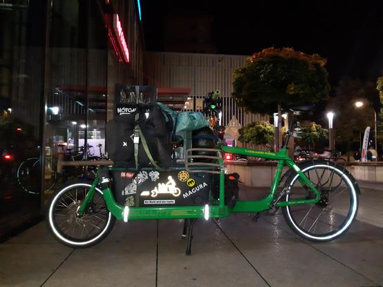 Grünes Bullitt Lastenrad mit allerhand Kram drauf gepackt